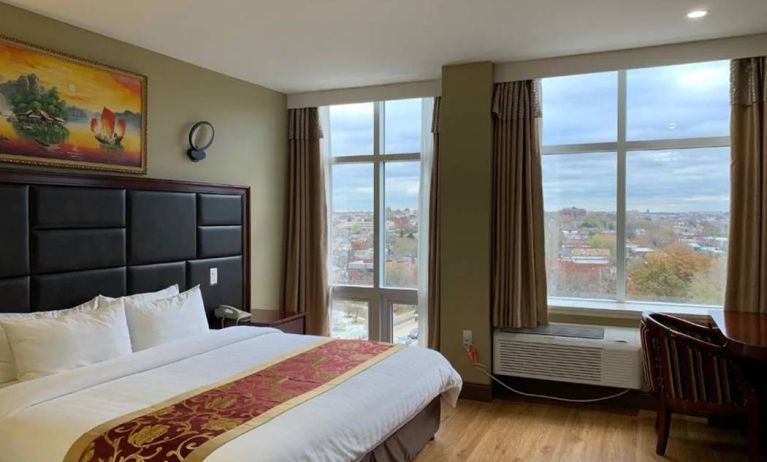 Guest room at the Queens Hotel, with double bed and large windows.