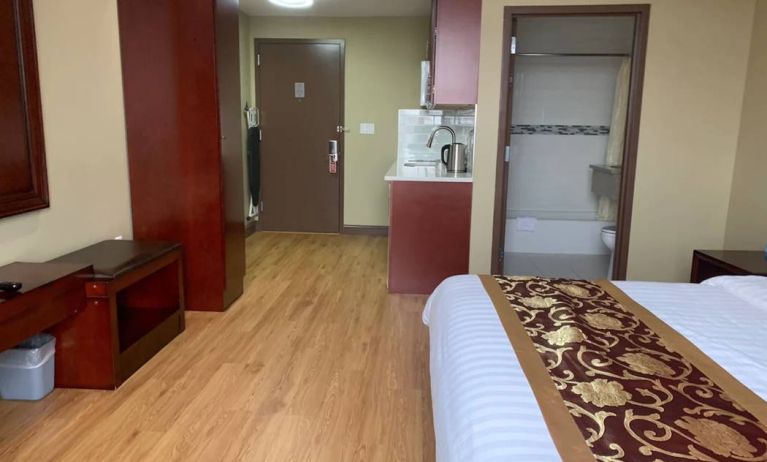 A Queens Hotel guest room, featuring a kitchenette area, and ensuite bathroom.