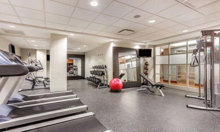 The hotel fitness center, equipped with weights, exercise bench, and various fitness machines.