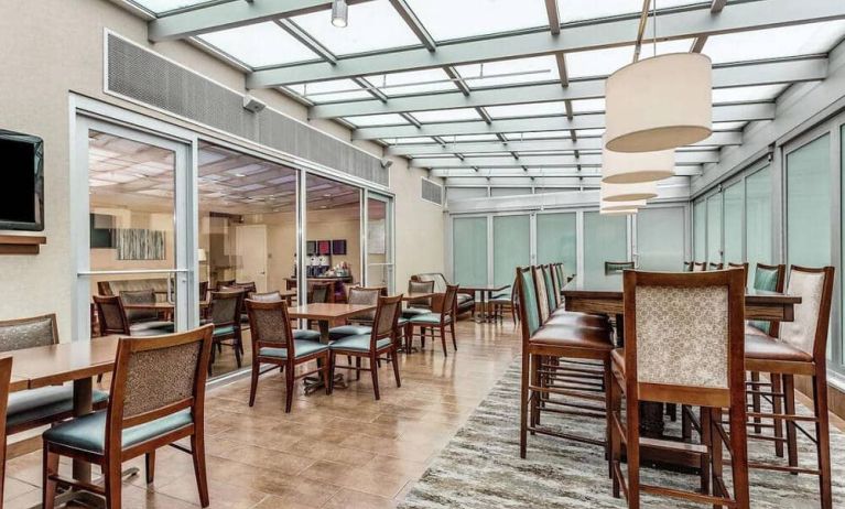 The hotel’s breakfast area, with hard floor and mix of regular and tall tables and chairs.