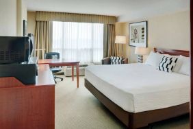 Double bed guest room in Radisson Hotel Kitchener Waterloo, with window, and workspace desk and chair.