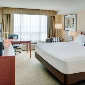 Double bed guest room in Radisson Hotel Kitchener Waterloo, with window, and workspace desk and chair.