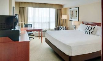 Double bed guest room in Radisson Hotel Kitchener Waterloo, with window, and workspace desk and chair.