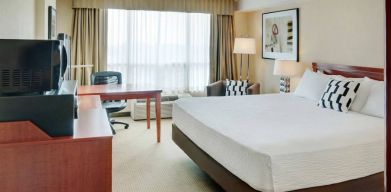 Double bed guest room in Radisson Hotel Kitchener Waterloo, with window, and workspace desk and chair.