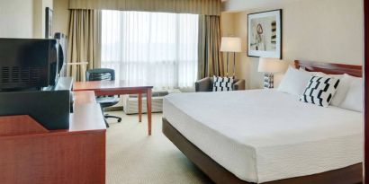 Double bed guest room in Radisson Hotel Kitchener Waterloo, with window, and workspace desk and chair.