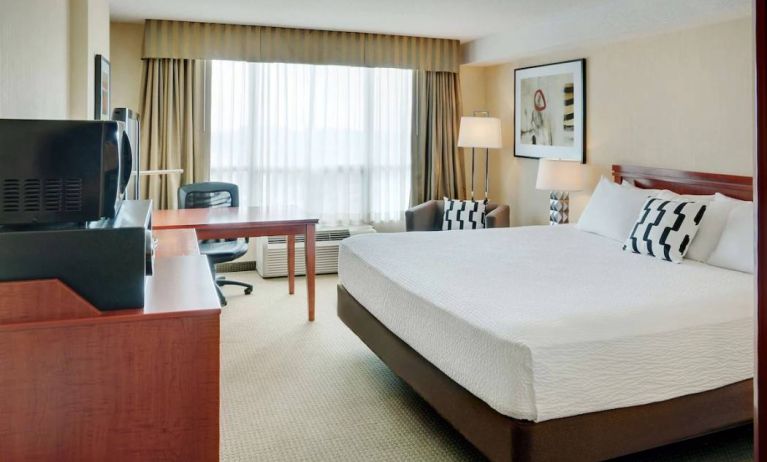 Double bed guest room in Radisson Hotel Kitchener Waterloo, with window, and workspace desk and chair.