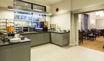 Food counter with pastry display container along with juice and coffee machine with seating lounge in adjacent room to eat, work, meet.