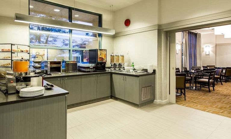 Food counter with pastry display container along with juice and coffee machine with seating lounge in adjacent room to eat, work, meet.