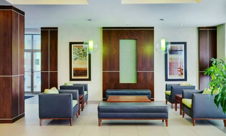 Allure Hotel & Conference Centre’s lobby has comfortable chairs, tables, and coffee tables.