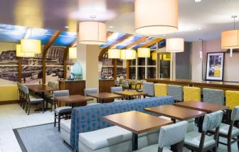 Blue and yellow colorful dining and lounge room at the Hampton Inn Manhattan - Madison Square Garden.