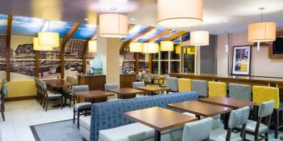 Blue and yellow colorful dining and lounge room at the Hampton Inn Manhattan - Madison Square Garden.