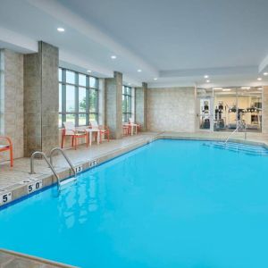 The hotel’s indoor pool has plenty of natural light and nearby chairs and tables.