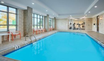 The hotel’s indoor pool has plenty of natural light and nearby chairs and tables.