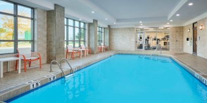 The hotel’s indoor pool has plenty of natural light and nearby chairs and tables.