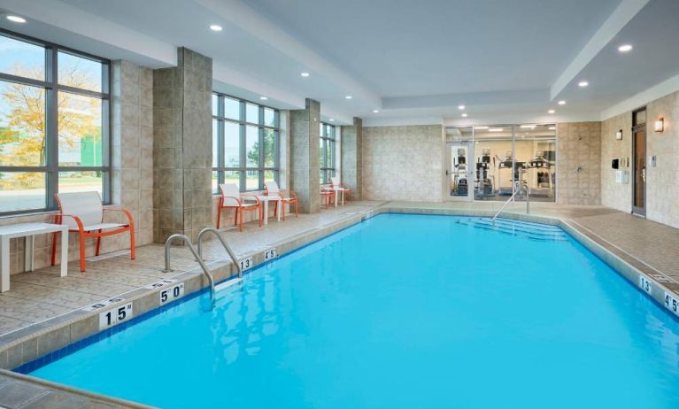 The hotel’s indoor pool has plenty of natural light and nearby chairs and tables.