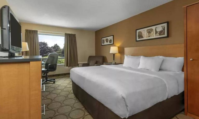 Double bed guest room in Comfort Inn Moncton Magnetic Hill, with large window and TV.