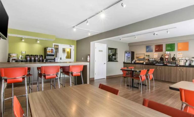 The hotel breakfast area has a hard floor and mix of standard and tall chair seating.