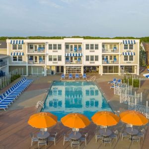 Outdoor pool with lounge chairs and umbrellas at Sea Crest Beach Hotel.