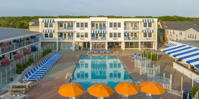 Outdoor pool with lounge chairs and umbrellas at Sea Crest Beach Hotel.