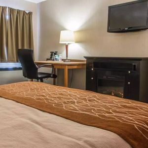 Guest room workspace in Comfort Inn Brandon, with a cozy fireplace beside the desk and chair.