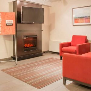 The hotel’s lobby has comfortable seating, a fireplace, and large TV screen.