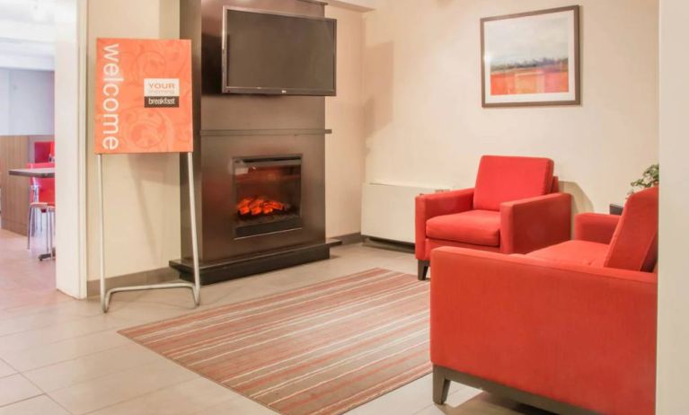 The hotel’s lobby has comfortable seating, a fireplace, and large TV screen.