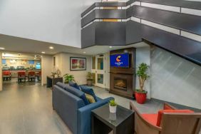 Lounge in the Comfort Inn Winnipeg Airport lobby, with comfy seating and cozy fireplace.