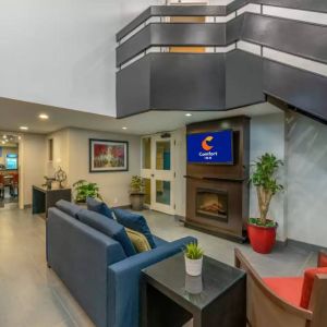 Lounge in the Comfort Inn Winnipeg Airport lobby, with comfy seating and cozy fireplace.