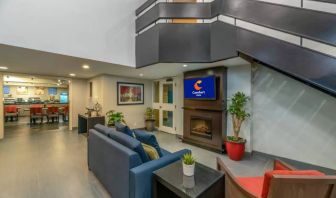 Lounge in the Comfort Inn Winnipeg Airport lobby, with comfy seating and cozy fireplace.