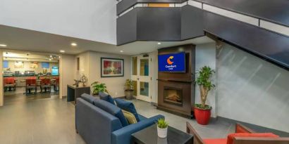 Lounge in the Comfort Inn Winnipeg Airport lobby, with comfy seating and cozy fireplace.