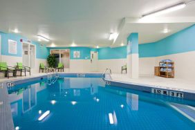 The hotel’s indoor swimming pool has nearby chairs and towels.