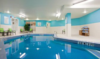 The hotel’s indoor swimming pool has nearby chairs and towels.