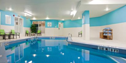 The hotel’s indoor swimming pool has nearby chairs and towels.