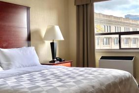 Guest room in Holiday Inn Winnipeg Downtown, with bedside lamp and window.