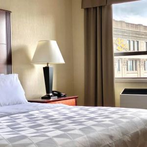 Guest room in Holiday Inn Winnipeg Downtown, with bedside lamp and window.