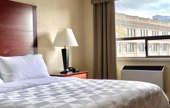 Guest room in Holiday Inn Winnipeg Downtown, with bedside lamp and window.