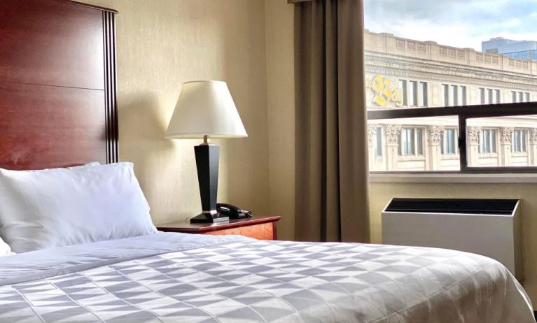 Guest room in Holiday Inn Winnipeg Downtown, with bedside lamp and window.