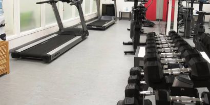 Hotel fitness center complete with rack of weights and various exercise machines.