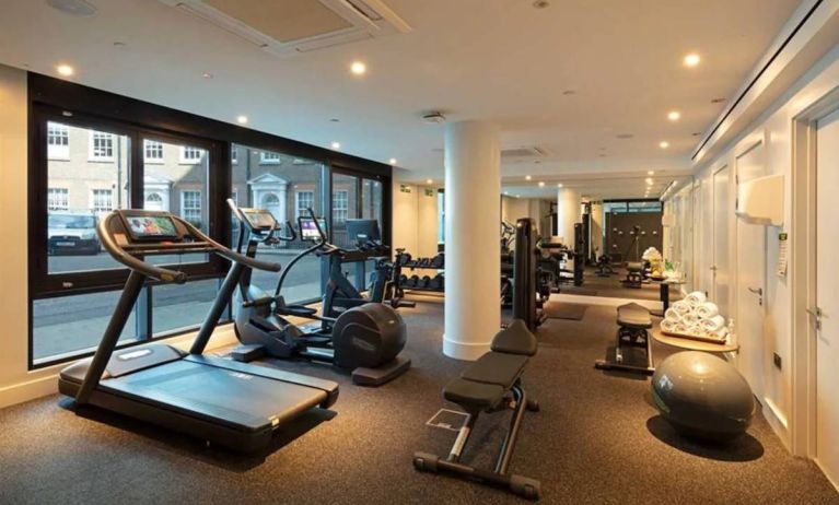 The hotel’s gym, featuring assorted exercise machines, large windows, and stacked weights.