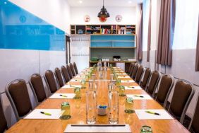 The Mandela meeting room of The Wesley Euston Hotel, with long table and seating for over a dozen attendees.