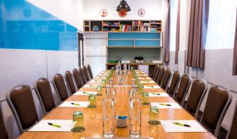 The Mandela meeting room of The Wesley Euston Hotel, with long table and seating for over a dozen attendees.