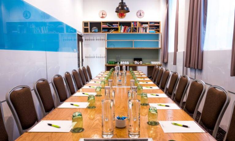 The Mandela meeting room of The Wesley Euston Hotel, with long table and seating for over a dozen attendees.