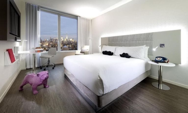 The Innside By Melia New York Nomad’s king room (city view), with large bed, TV, and the eponymous urban vista through the window.