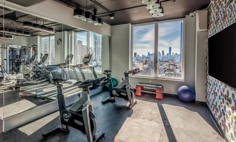 The hotel’s fitness center, with urban view and assorted exercise machines.