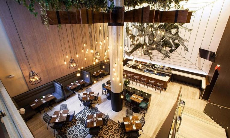 On-site restaurant and bar at Innside By Melia New York Nomad, with varying table sizes and bar stool seating.