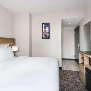 Double bed guest room in the DoubleTree Times Square South, with art on the wall and large TV.