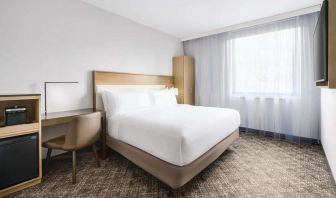 Guest room in the DoubleTree Times Square South, with double bed and workspace desk and chair.