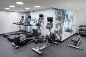 The hotel exercise center, fitted with rack of weights, bench, and multiple exercise machines.