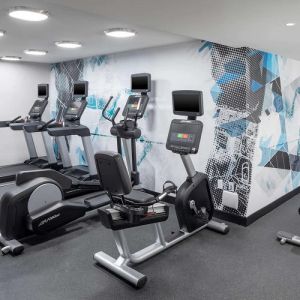 The hotel exercise center, fitted with rack of weights, bench, and multiple exercise machines.