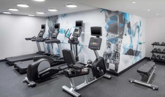 The hotel exercise center, fitted with rack of weights, bench, and multiple exercise machines.